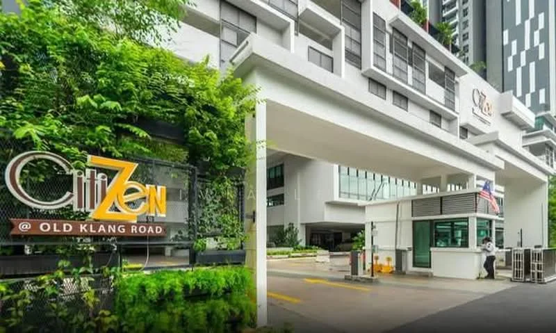 Exterior type: high-rise condominium; features: modern facade with glass curtain wall, white painted facade, landscaped entrance with greenery, security guard house at entrance, driveway with interlocking pavers, visible signage for 'CitiZen @ Old Klang Road', multiple storeys, surrounded by urban environment; style: modern.