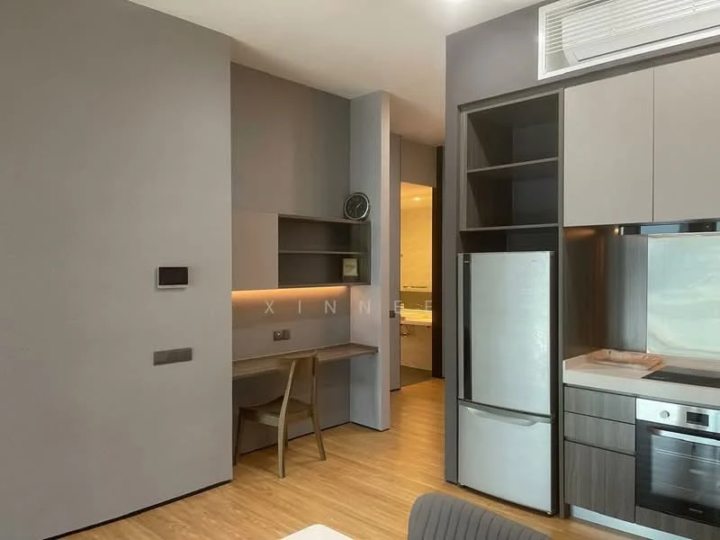Room features: light wood flooring, grey painted walls, built-in cabinetry with grey and wood finish, stainless-steel fridge, built-in oven, cooktop, kitchen island, wall-mounted air conditioning unit, desk with wooden legs, wall clock, open shelving, recessed lighting; style: modern.