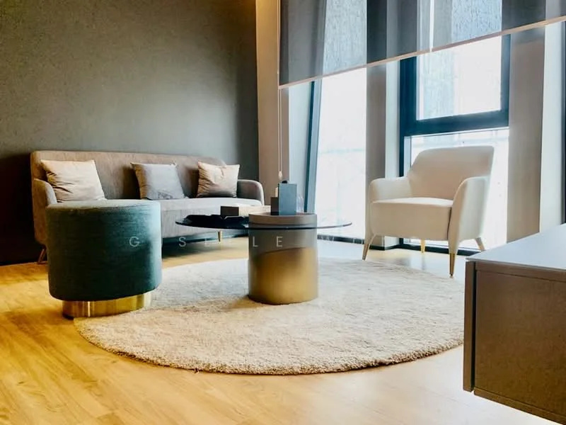 Living features: 3-seater fabric sofa in grey, 2 accent pillows, round coffee table with metallic base, area rug with circular shape, floor-to-ceiling windows, sheer curtains, wooden flooring, accent chair in white, decorative items on coffee table; style: modern; view: city.