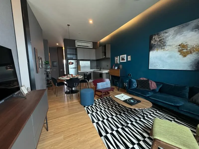 Living features: blue accent wall, grey painted walls, wooden flooring, 3-seater fabric sofa in teal, 2 accent chairs in blue, coffee table with wooden top, area rug with geometric pattern, wall-mounted TV, TV console, decorative artwork, recessed lighting, open-plan layout to kitchen; style: modern. Kitchen features: stainless-steel fridge, built-in oven, freestanding range oven, grey cabinetry, white countertop, kitchen island with seating, recessed downlights; style: modern.