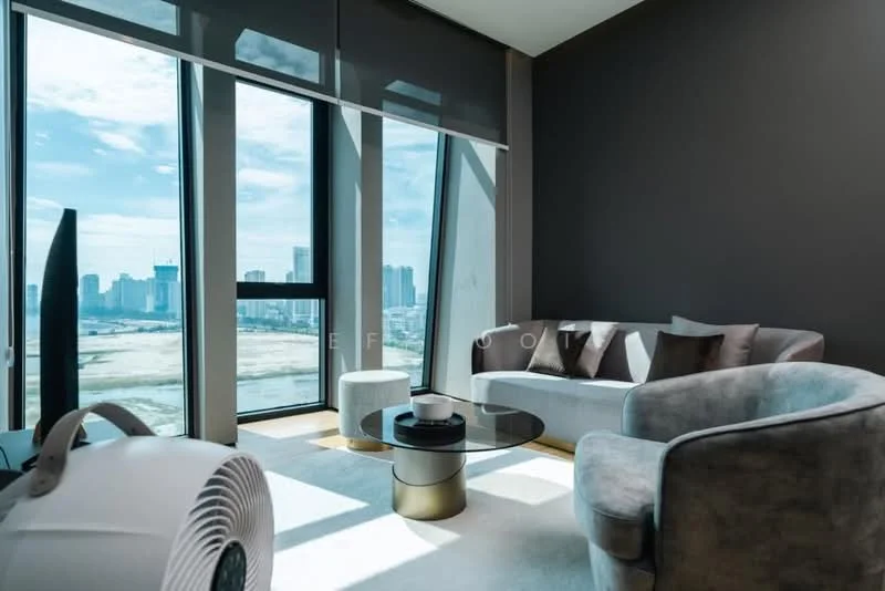 Living features: floor-to-ceiling windows, grey accent wall, light grey sofa, round glass coffee table, white side table, decorative cushions, city skyline view, light-colored area rug, fan, natural light; style: modern; view: city.