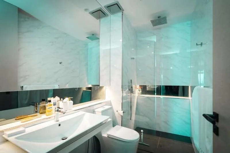 Bathroom features: white marble wall cladding, mirrored wall, floating vanity with sink, chrome basin mixer faucet, backlit mirror, one-piece toilet, glass shower enclosure, recessed ceiling lights, dark tile flooring; style: modern.