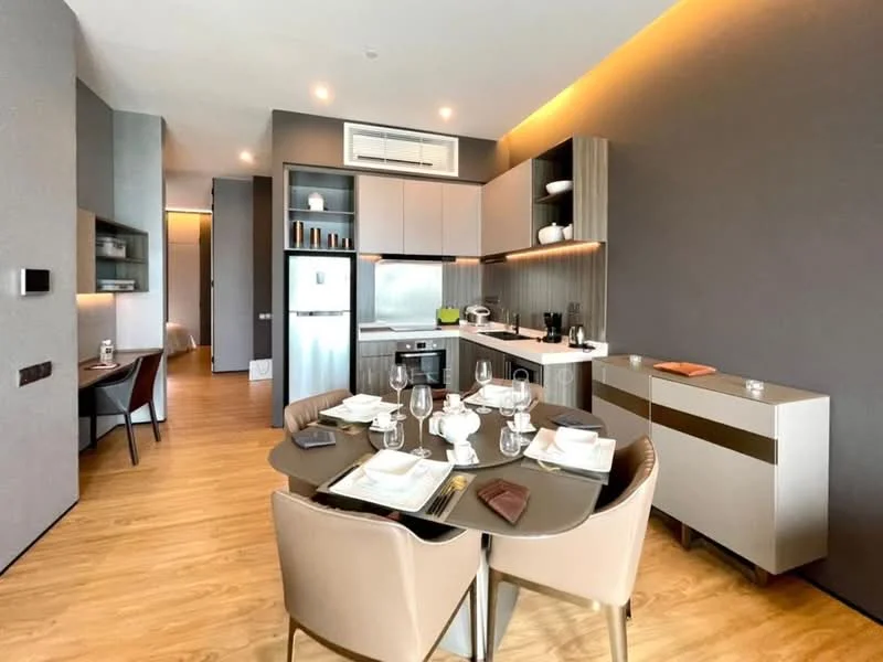 Kitchen features: open-plan layout, grey painted walls, wooden flooring, white cabinetry with flat-panel design, stainless-steel fridge, built-in oven, 4-burner gas hob, chrome pull-down faucet, single-bowl stainless-steel sink, quartz countertop, dining table with 4 upholstered chairs, table setting with plates and glasses, recessed downlights, air conditioning unit; style: modern.
