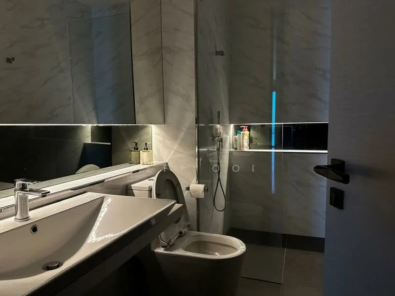 Bathroom features: single-sink vanity with white cabinet, chrome basin mixer faucet, large wall-mounted mirror, grey marble wall tiles, glass shower enclosure, handheld shower, toilet, recessed LED lighting, dark flooring, bottle and soap dispenser on vanity; style: modern.