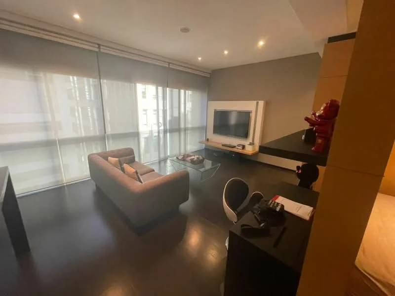 Living features: 3-seater fabric sofa in grey, glass coffee table, wall-mounted TV, TV console, black desk with chair, floor-to-ceiling windows, sheer curtains, dark wood flooring, recessed downlights, decorative figure on shelf; style: modern.