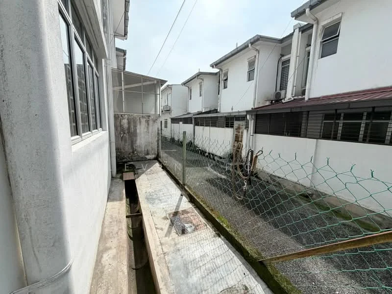 Exterior type: linked terrace house; features: white painted facade, single-storey, concrete walkway, fenced area, gravel surface, visible drainage system, adjacent houses, overhead power lines; style: modern.