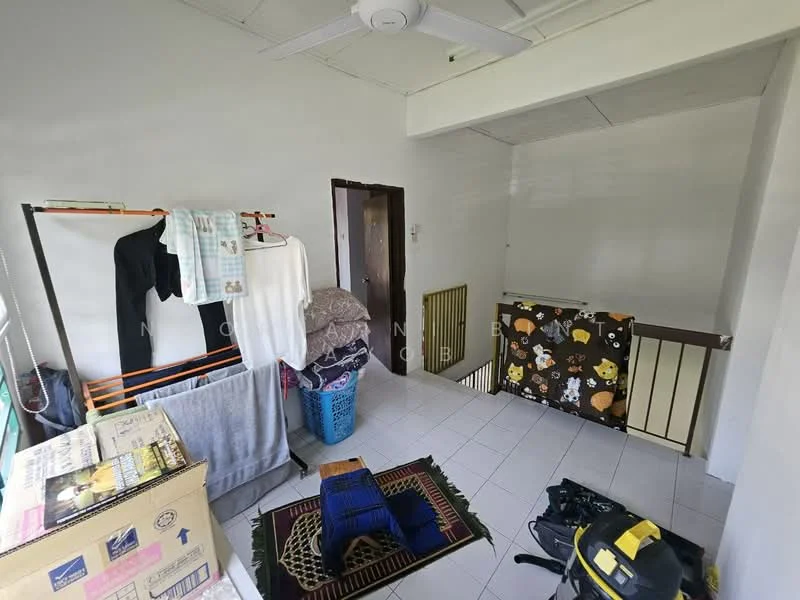 Room features: white painted walls, white ceiling, tile flooring, 5-blade ceiling fan, laundry drying rack, clothes hanging on rack, stack of blankets, laundry basket, area rug with geometric pattern, cardboard boxes, black bag on floor.