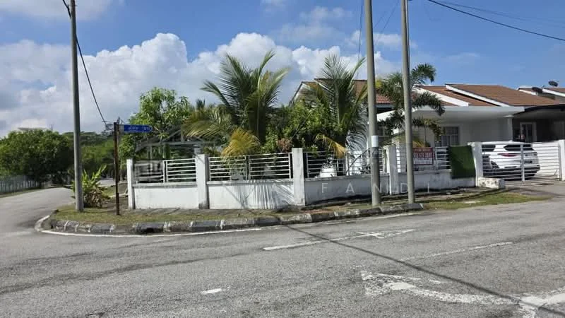 Exterior type: detached bungalow; features: white painted facade, pitched tile roof, manicured lawn, mature palm trees, fenced front yard, driveway with interlocking pavers, corner lot, surrounded by greenery; style: modern.