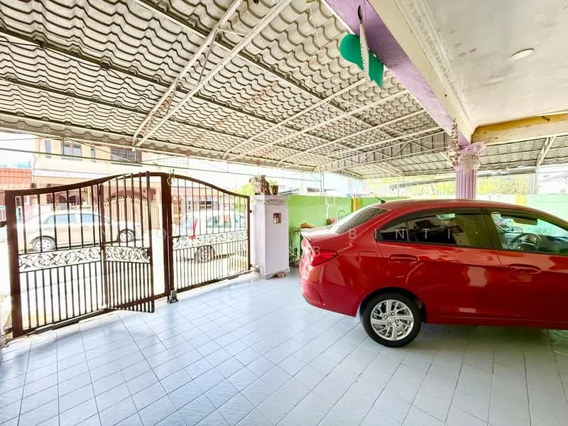 Exterior type: car porch; features: covered car porch, red sedan car, tiled flooring, metal gate, green wall, overhead roof with patterned design, columns supporting the roof; style: modern.