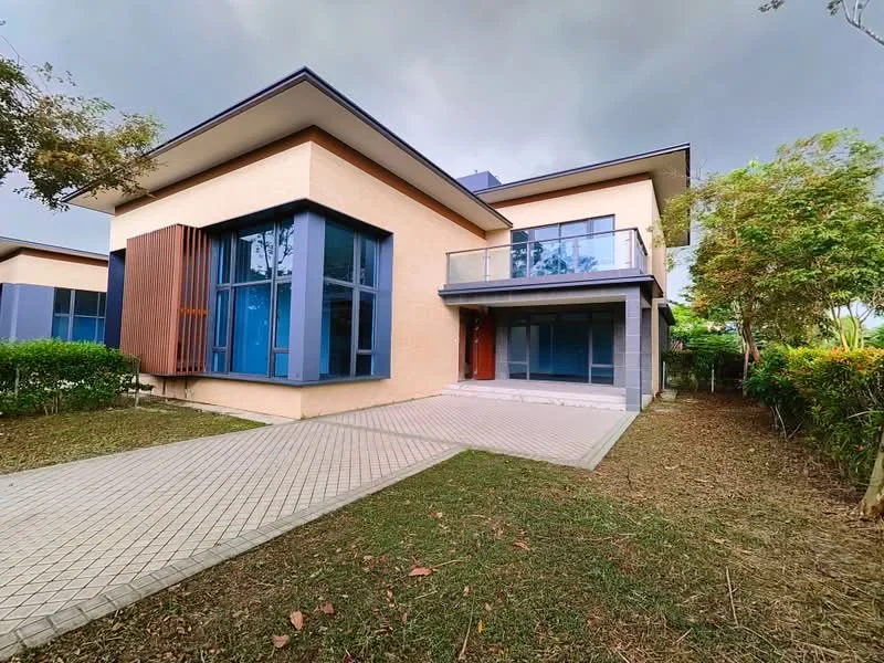 Exterior type: detached bungalow; features: cream painted facade, large floor-to-ceiling windows, wooden accent paneling, flat roof, manicured lawn, paved driveway, surrounded by greenery; style: modern.