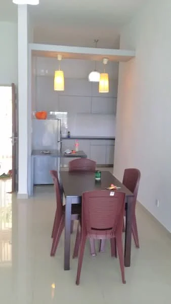 Dining features: dining table with four chairs, white walls, recessed ceiling lights, pendant lights above table, ceramic tile flooring, stainless-steel fridge, kitchen cabinetry with glossy finish, open kitchen layout; style: modern.