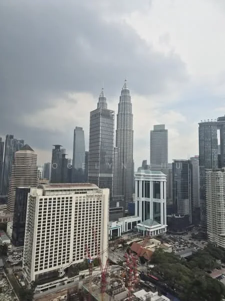 Exterior type: high-rise condominium; features: glass curtain wall, white painted facade, recessed balconies, surrounded by mature greenery, urban context with skyline view, construction cranes visible; style: modern.