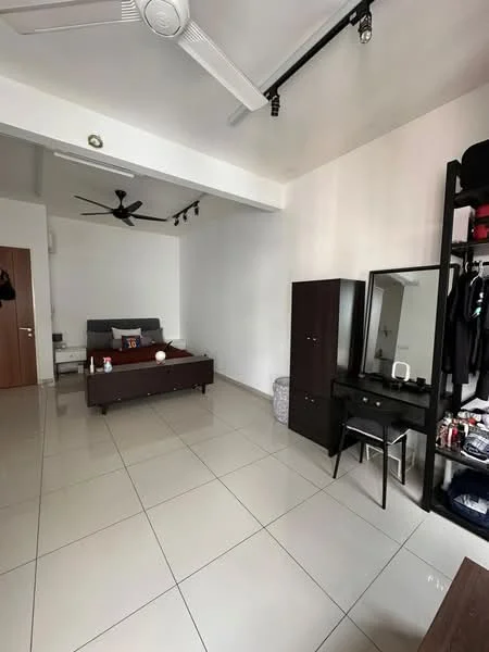 Room features: white painted walls, polished ceramic tile flooring, 5-blade ceiling fan, wall-mounted mirror, black dressing table, wooden wardrobe, bed with grey upholstered headboard, decorative items on the bed, small waste bin, clothing rack, track lighting on ceiling; style: modern.