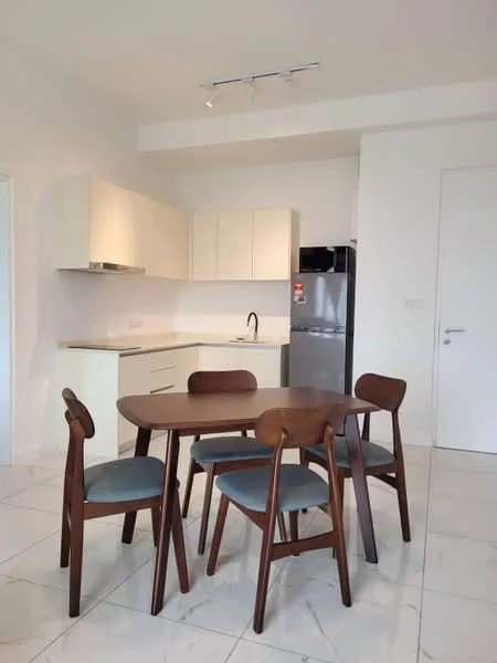 Dining features: 4-seater wooden dining table, wooden dining chairs with grey upholstery, white cabinetry, stainless-steel fridge, single-bowl stainless-steel sink, chrome pull-down faucet, white countertop, ceramic tile flooring, track lighting, white painted walls; style: modern. Kitchen features: white cabinetry, white countertop, stainless-steel fridge, single-bowl stainless-steel sink, chrome pull-down faucet, ceramic tile flooring; style: modern.