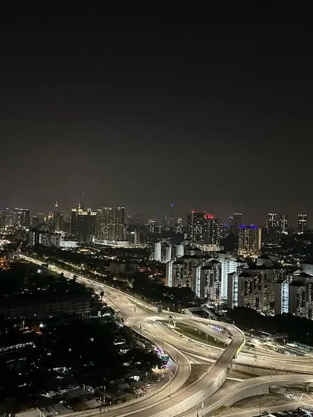 Exterior type: high-rise condominium; features: city skyline view, nighttime lighting, curved highway, urban landscape, high-rise buildings, illuminated structures; style: modern.