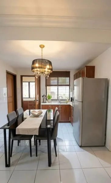 Kitchen features: dark wooden cabinetry, stainless-steel fridge, white tiled flooring, black dining table with four chairs, chandelier light fixture, window with blinds, sink with gooseneck faucet, countertop with backsplash, wooden door, open layout; style: modern.
