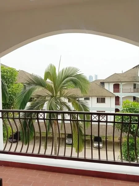 Balcony features: arched balcony with metal railing, brick flooring, potted palm tree, view of neighboring buildings, view of parked cars, greenery in the vicinity; view: garden.