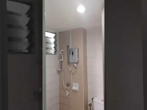 Bathroom features: shower with handheld showerhead, wall-mounted water heater, white tiled walls, light-colored tile flooring, toilet, glass window with louvered design, recessed ceiling lights; style: modern.