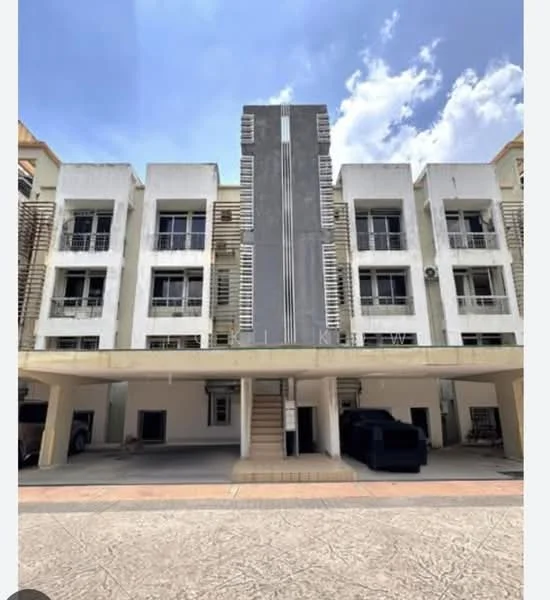 Exterior type: low-rise apartment block; features: white painted facade, vertical fins on facade, flat roof, approximately 3-storey, open parking area underneath, staircase leading to upper floors, balconies with metal railings, air conditioning units visible, manicured pathway, surrounded by clear blue sky; style: modern.