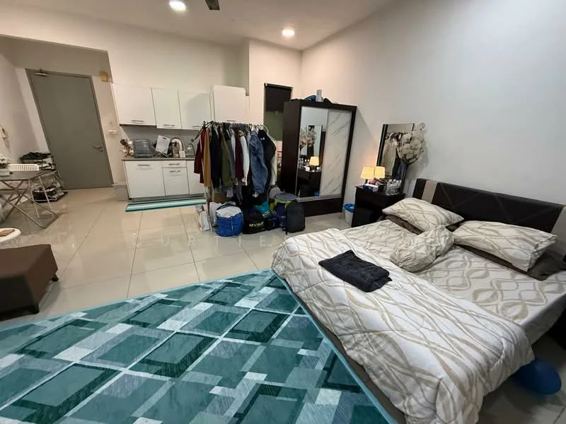 Bedroom features: king-size bed with patterned bedding, upholstered headboard, bedside lamp, built-in wardrobe with mirror, white painted walls, tile flooring, area rug with geometric pattern, clothes rack with hanging clothes, kitchenette with white cabinets, stainless-steel sink, refrigerator, microwave, small dining table, folding chair; style: modern.