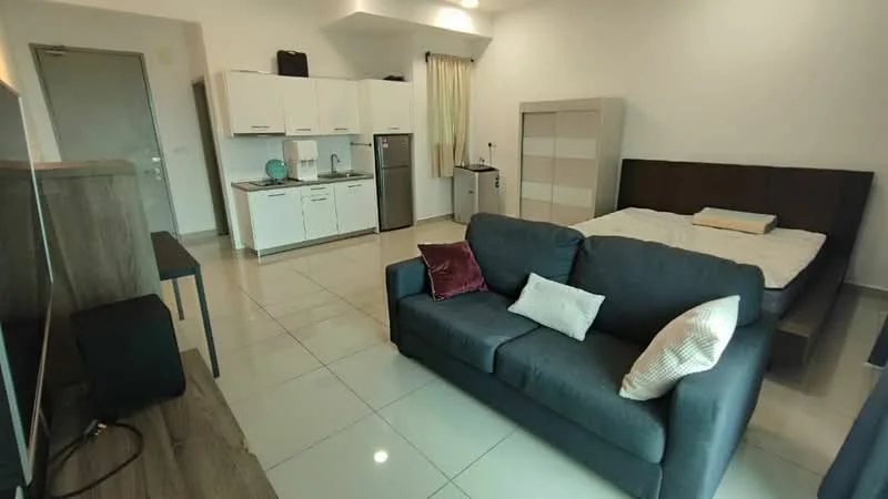 Living features: grey fabric sofa, white throw pillows, flat-screen TV on console, wooden TV console, tile flooring, recessed ceiling lights, window with sheer curtains, open layout to kitchen and bedroom area; style: modern. Kitchen features: white cabinetry, stainless-steel fridge, built-in microwave, sink with chrome faucet, ceramic tile backsplash, countertop with space for appliances, kitchen island with seating, tile flooring; style: modern. Bedroom features: queen-size bed, wooden headboard, bedding in neutral tones, built-in wardrobe, nightstand, recessed ceiling lights, tile flooring; style: modern.