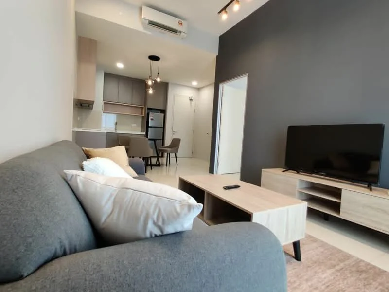 Living features: grey fabric sofa, coffee table in light wood, TV console in light wood, wall-mounted TV, recessed ceiling lights, air conditioning unit, cream area rug, decorative cushions, open-plan layout to kitchen, light-colored walls, dark accent wall; style: modern.