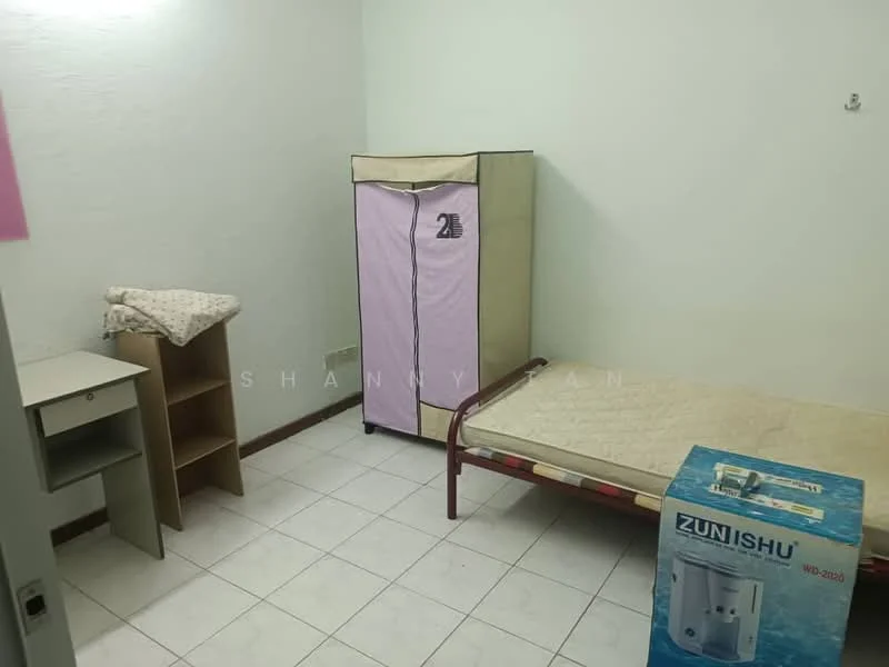 Room features: white painted walls, tile flooring, single bed frame with mattress, foldable wardrobe with pink cover, wooden bookshelf, small bedside table, water dispenser, window with no visible treatment.