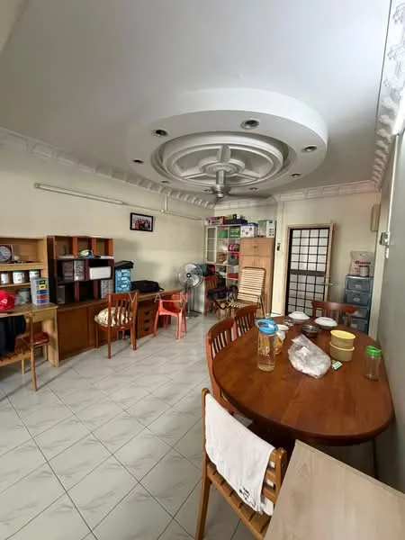 Dining features: round wooden dining table, 4 wooden dining chairs, ceiling fan with integrated light, white painted walls, tile flooring, built-in wooden shelving unit, freestanding wooden cabinet, decorative ceiling design, window with sheer curtains, wall-mounted photo frame, plastic storage containers, glass jars on table.