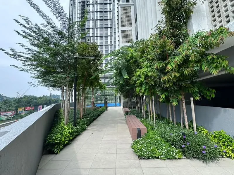 Exterior type: high-rise condominium; features: landscape garden, manicured lawn, mature trees, stone-paved walkway, outdoor seating area with benches, swimming pool visible in background, tropical landscaping; style: modern.