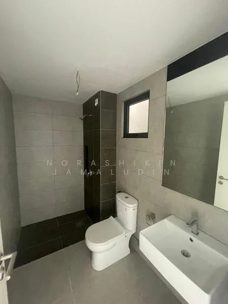 Bathroom features: grey tiled walls, dark grey tiled flooring, walk-in shower with glass enclosure, chrome handheld shower, wall-mounted sink, single-sink vanity, one-piece toilet, framed mirror, window for natural light, ceiling light fixture; style: modern.