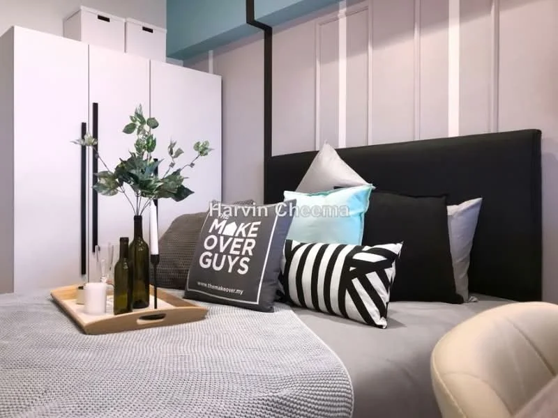 Bedroom features: king-size bed with black upholstered headboard, decorative pillows in various colors and patterns, light grey bedding, white bedside table, decorative tray with bottles and a candle, wall-mounted artwork with text, white wardrobe, light grey wall with vertical paneling, blue accent wall, floor lamp, area rug; style: modern.