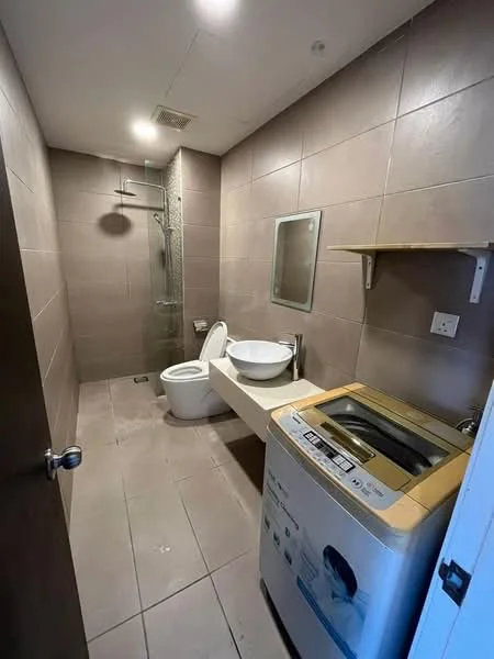 Bathroom features: grey tiled walls, light grey tiled flooring, walk-in shower with glass enclosure, rain shower head, toilet, single-sink vanity with bowl sink, mirror, wooden shelf, washing machine; style: modern.