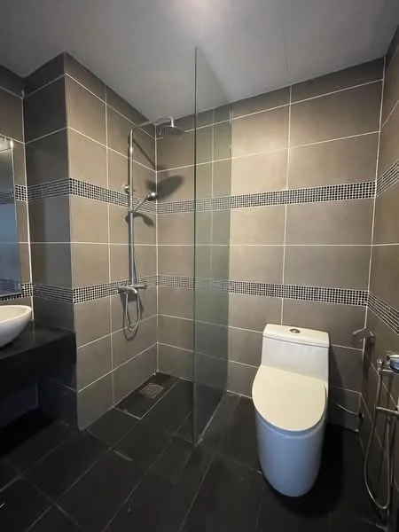 Bathroom features: walk-in shower with glass enclosure, chrome handheld shower, chrome rain shower head, black tiled flooring, grey tiled walls, mosaic tile accent strip, white one-piece toilet, wall-mounted faucet, round basin sink, mirror above sink, towel rail; style: modern.