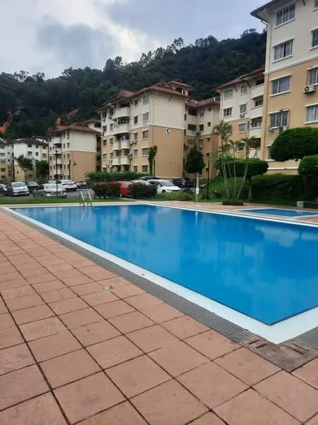 Exterior type: low-rise apartment block; features: swimming pool, pool deck with loungers, manicured lawn, mature trees, surrounded by greenery, parking lot, multiple storey buildings, paved walkway; style: modern.