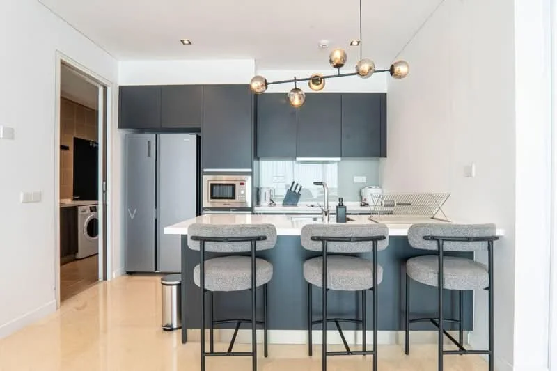 Kitchen features: grey cabinetry, white countertop, stainless-steel fridge, built-in microwave, stainless-steel oven, 4-burner gas hob, single-bowl stainless-steel sink, chrome pull-down faucet, pendant light fixture, bar seating with 3 stools, cream tiled flooring, wall-mounted cabinets; style: modern. Laundry features: front-load washing machine, dark cabinetry.