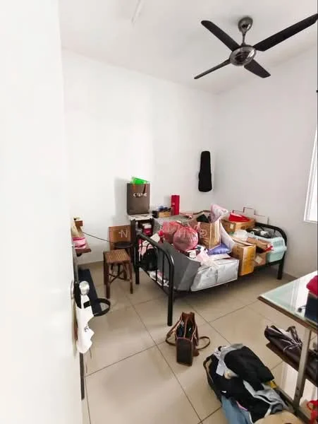 Room features: white painted walls, ceiling fan, tile flooring, single bed, black metal bed frame, various boxes and bags, window with blinds, cluttered space.