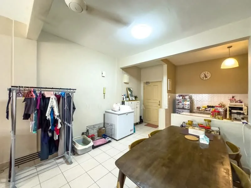 Dining features: dining table, wooden dining chairs, white tiled flooring, cream painted walls, ceiling light fixture, wall-mounted clock, clothes rack, refrigerator, kitchen counter with cabinets, open kitchen layout, sink, kitchen appliances visible.