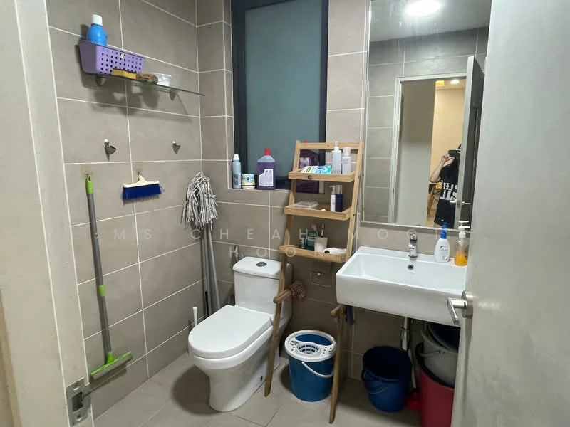 Bathroom features: grey tiled walls, ceramic tile flooring, one-piece toilet, single-sink vanity with wall-mounted faucet, framed mirror, wooden shelving unit, cleaning supplies on wall hooks, laundry basket, plastic storage bins; style: modern.
