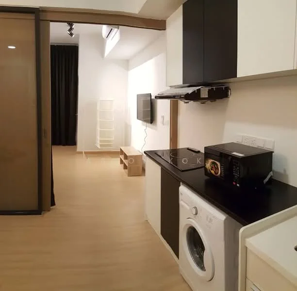 Room features: light wood flooring, white walls, black countertop, built-in cabinetry, washing machine, microwave, television, black accent wall, floor-to-ceiling windows with sheer curtains, recessed lighting, open layout, laundry area; style: modern.