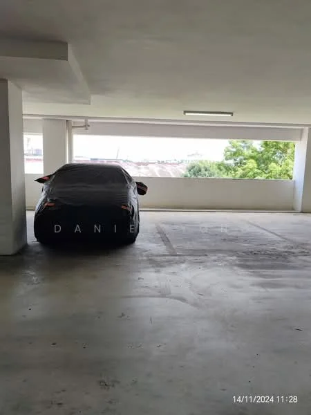 Exterior type: parking deck; features: concrete flooring, covered parking area, open-air design, natural light from windows, white painted walls, single parking space, surrounding greenery visible; style: modern.