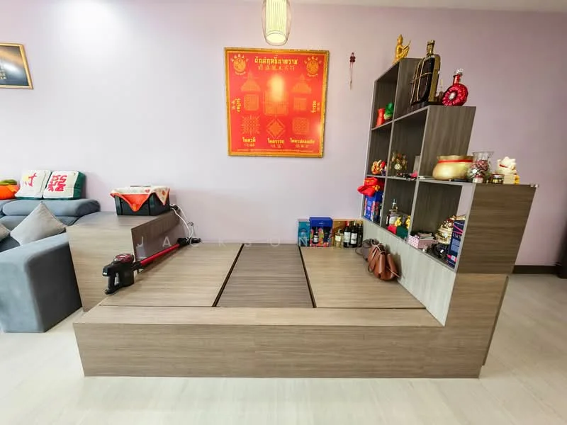 Room features: light purple painted walls, laminate flooring, built-in wooden shelving unit, decorative items on shelves, seating area with cushions, low wooden platform, wall-mounted decorative piece, hanging pendant light; style: modern.