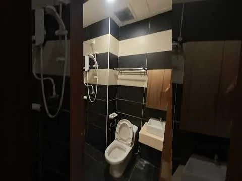 Bathroom features: one-piece toilet, wall-mounted shower head, handheld shower, sink with cabinet, black and cream tiled walls, dark tile flooring, mirror above sink, grab bar, shower curtain rod; style: modern.