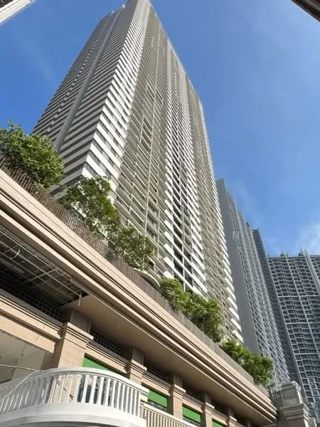 Exterior type: high-rise condominium; features: glass curtain wall, white painted facade, recessed balconies, vertical fins, landscaped terrace with trees, multiple storeys, surrounded by other high-rise buildings; style: modern.