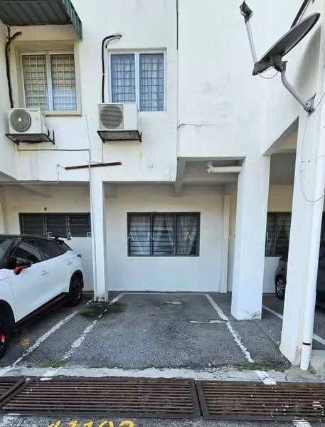 Exterior type: low-rise apartment block; features: 2 parking spaces, white painted facade, air conditioning units on wall, concrete flooring, windows with grilles, ground-level entrance, visible drainage system, surrounding pavement; style: modern.