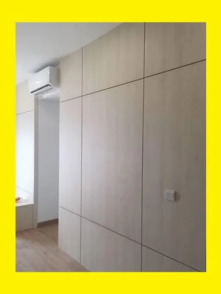 Room features: light wood panelled walls, laminate flooring, wall-mounted split AC; style: modern.