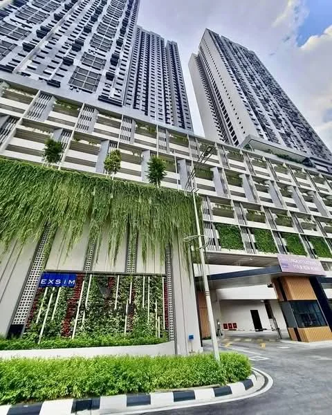 Exterior type: high-rise condominium; features: green wall with vertical garden, glass curtain wall facade, two tall residential towers, covered parking area, landscaped entrance with greenery, modern architectural design, driveway with interlocking pavers, signage for EXSIM, surrounded by urban landscape; style: modern.