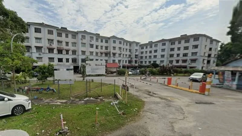 Exterior type: low-rise apartment block; features: 3-storey building, white painted facade, manicured lawn, parking area, surrounded by greenery, entrance with security gate, visible car parking, sidewalk, landscaped garden, multiple windows, balconies on upper floors; style: modern.