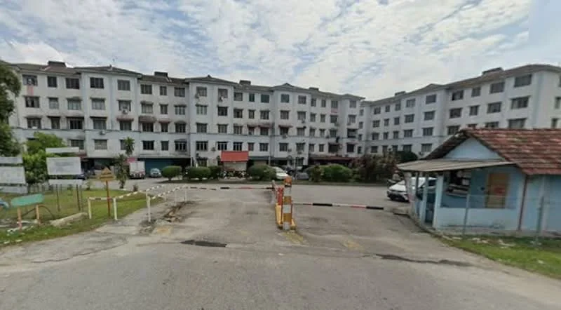 Exterior type: low-rise apartment block; features: white painted facade, multiple storeys, balconies on upper floors, parking area in front, manicured lawn, surrounding greenery, guard house at entrance, access control gate; style: modern.