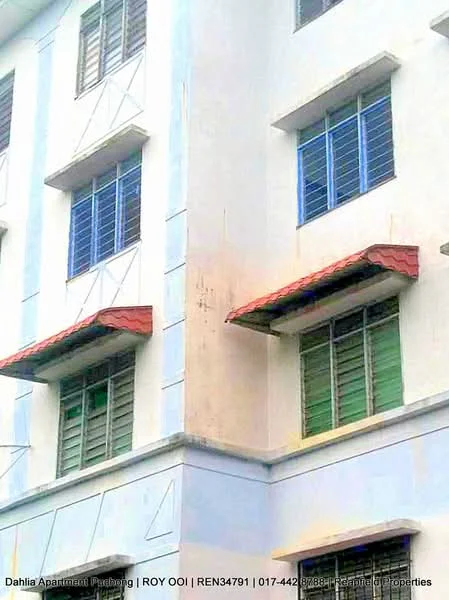 Exterior type: low-rise apartment block; features: white painted facade, blue painted accents, red pitched tile roof, green and blue window frames, horizontal louvered windows, two-storey building, visible stains on the wall; style: modern.