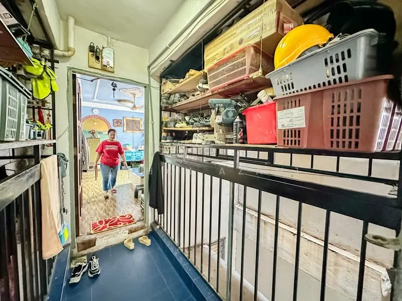 Room features: blue tile flooring, metal railing, wooden shelves, storage boxes, plastic baskets, various tools and equipment, doorway leading to another room, hanging clothes, decorative rug, overhead lighting; style: functional.